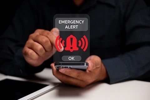 Smarttelefon viser et rødt nødvarsel med varselsymbol og